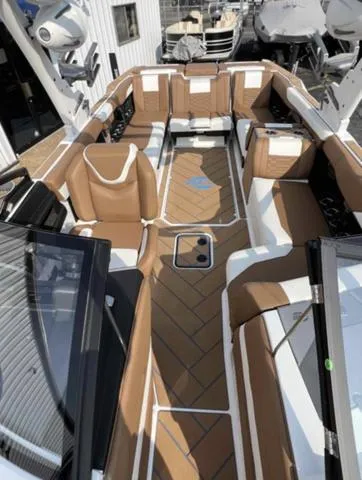 Slide: The Image of 2023 Malibu 26 LSV boat interior with brown and white seating. - 12