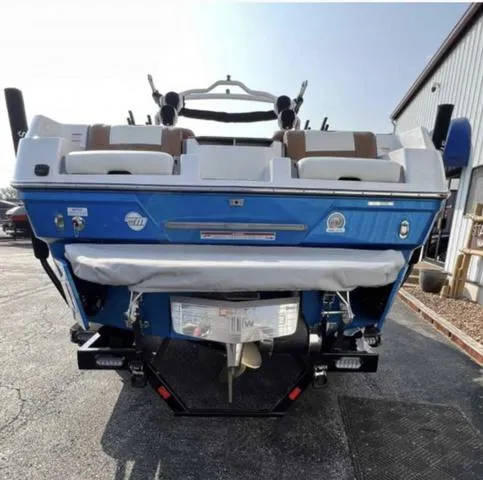 Slide: The Image of 2023 Malibu 26 LSV boat, rear view, blue exterior, docked outside. - 4