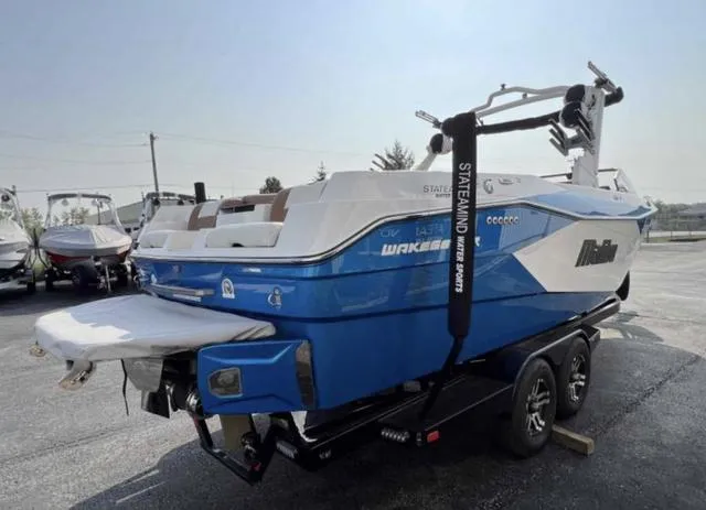 Slide: The Image of 2023 Malibu 26 LSV wakeboard boat in blue on trailer. - 5