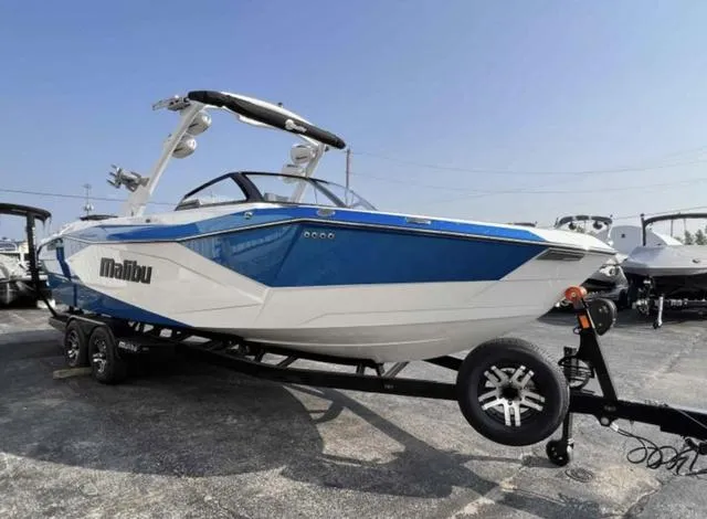 Slide: The Image of 2023 Malibu 26 LSV boat on trailer, blue and white exterior. - 6