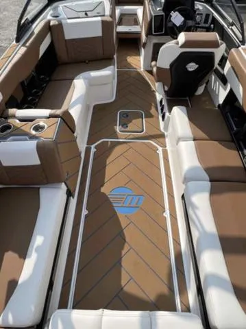 Slide: The Image of 2023 Malibu 26 LSV boat interior with brown and white seating and modern dashboard. - 8