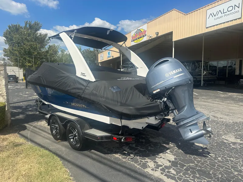 Slide: The Image of 2023 Regal 21 OBX boat with Yamaha outboard motor, covered and on a trailer. - 3