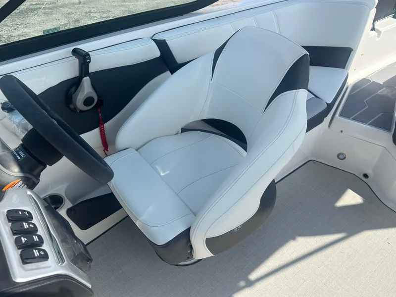 Slide: The Image of 2023 Regal 21 OBX boat interior with white and black captain's chair and steering wheel. - 42