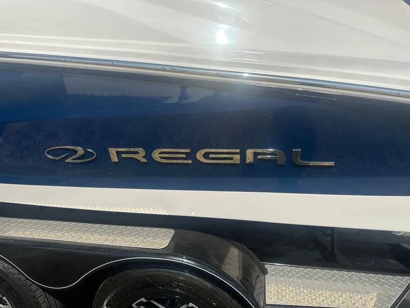Slide: The Image of 2023 Regal 21 OBX boat with blue and white exterior, featuring the Regal logo. - 48