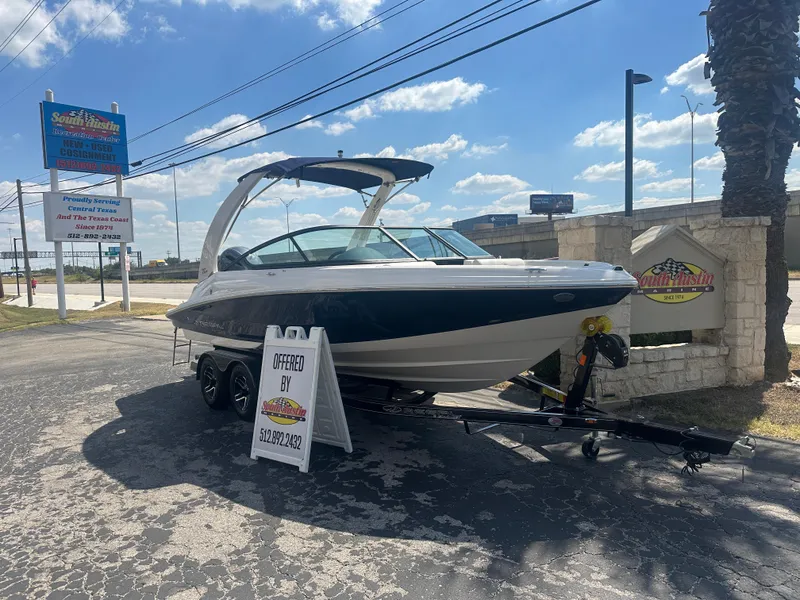 Slide: The Image of 2023 Regal 21 OBX boat on trailer at dealership under blue sky. - 5