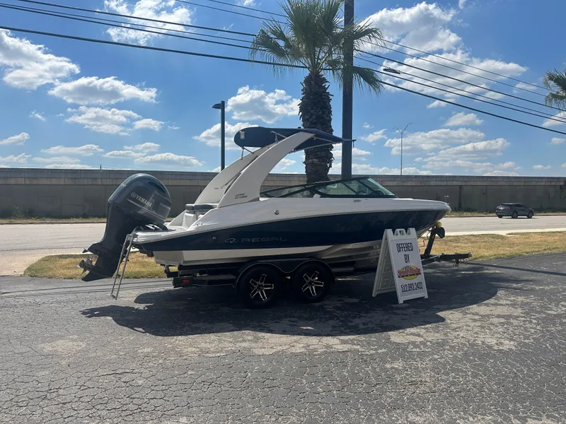Slide: The Image of 2023 Regal 21 OBX boat displayed outdoors with a price sign, under a sunny sky. - 6