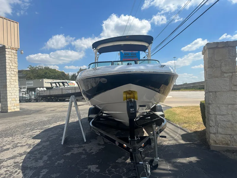 Slide: The Image of 2023 Regal 21 OBX boat on trailer, parked outdoors under a clear blue sky. - 7