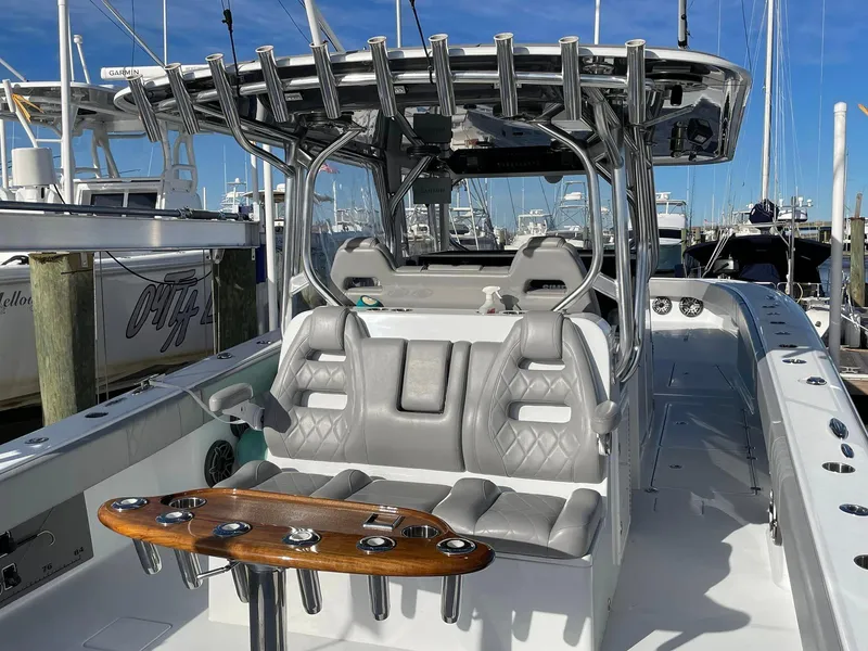 Slide: The Image of 2020 Freeman 42 LR boat with sleek seating and fishing rod holders at a marina. - 23