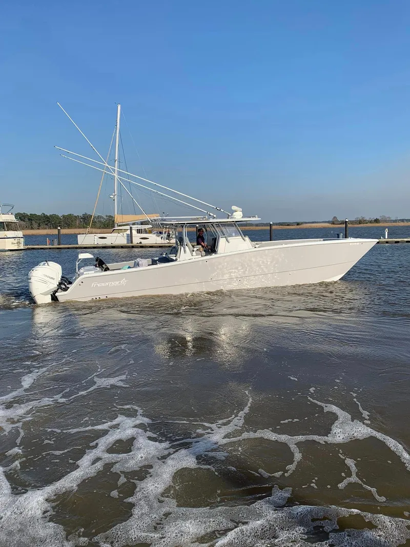 Slide: The Image of 2020 Freeman 42 LR boat cruising on calm waters near a marina. - 26