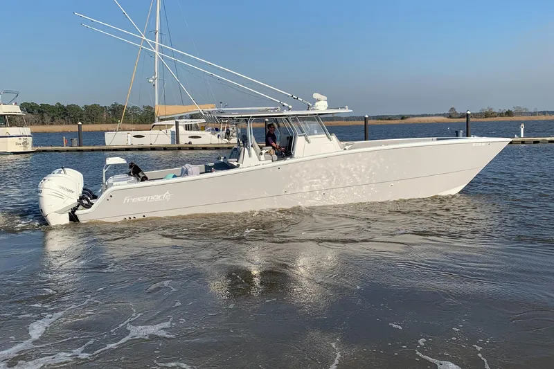 Slide: The Image of 2020 Freeman 42 LR boat cruising on a calm river near a marina. - 38