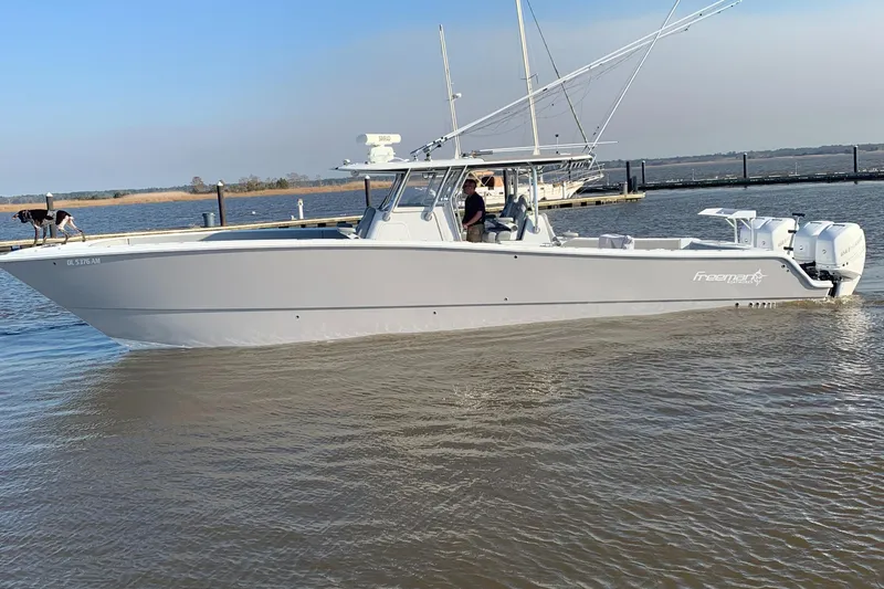 Slide: The Image of 2020 Freeman 42 LR boat on water with dog and person onboard. - 39