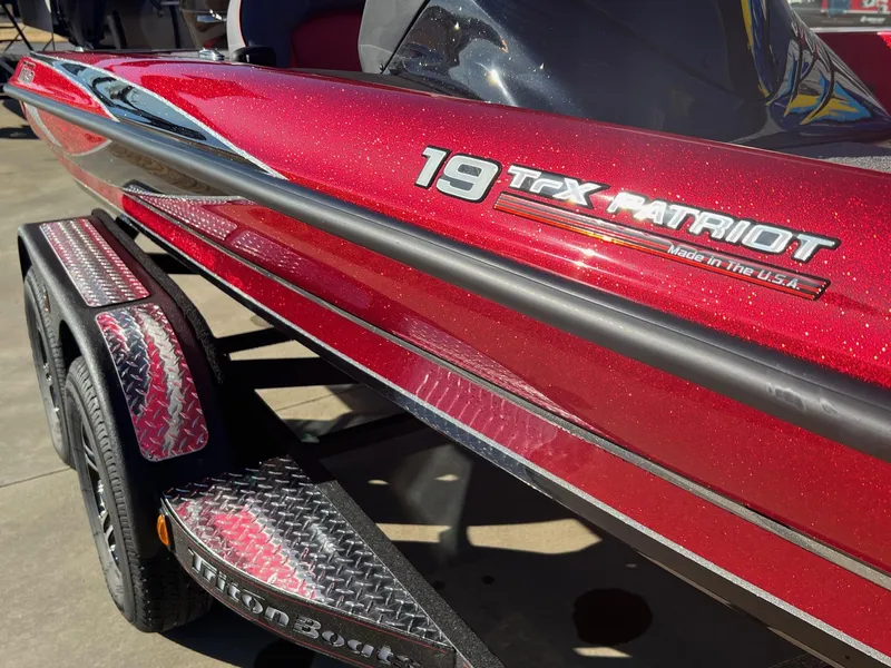Slide: The Image of 2024 Triton 19 TrX Patriot boat in red with trailer. - 12