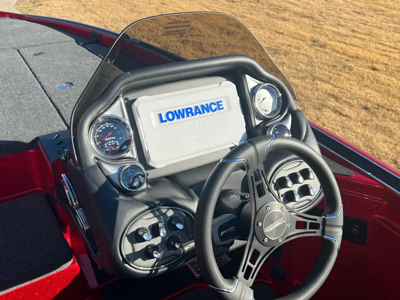 Slide: The Image of 2024 Triton 19 TrX Patriot boat dashboard with Lowrance display and steering wheel. - 13