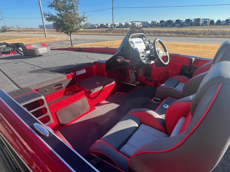 Slide: The Image of 2024 Triton 19 TrX Patriot boat interior with red and gray seating and dashboard. - 14