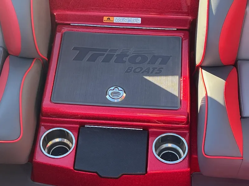 Slide: The Image of 2024 Triton 19 TrX Patriot boat interior with storage compartment and cup holders. - 17