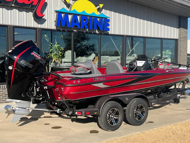 Slide: The Image of 2024 Triton 19 TrX Patriot boat in red, parked outside a marine dealership. - 5