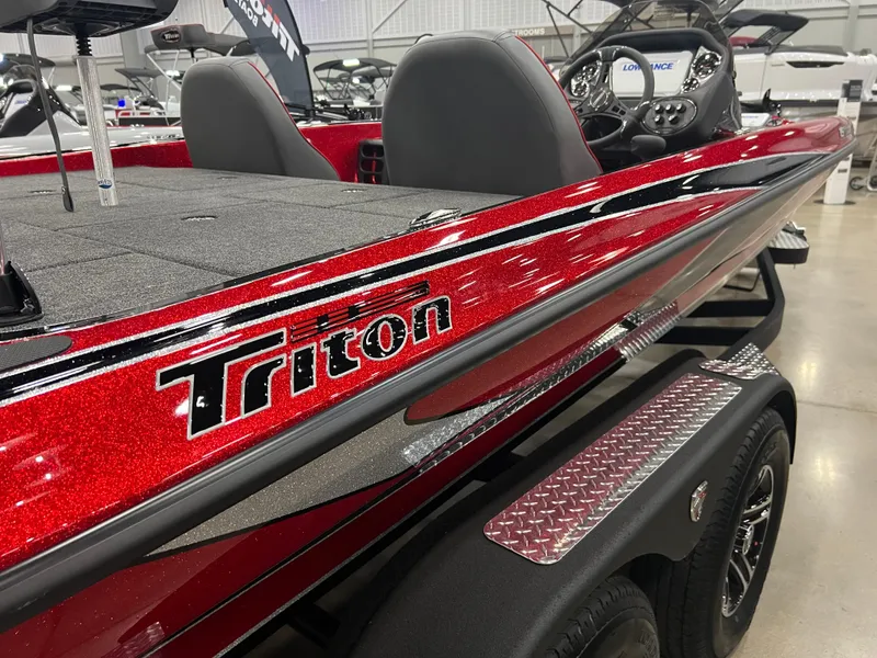 Slide: The Image of 2024 Triton 19 TrX Patriot bass boat in red, displayed indoors. - 6