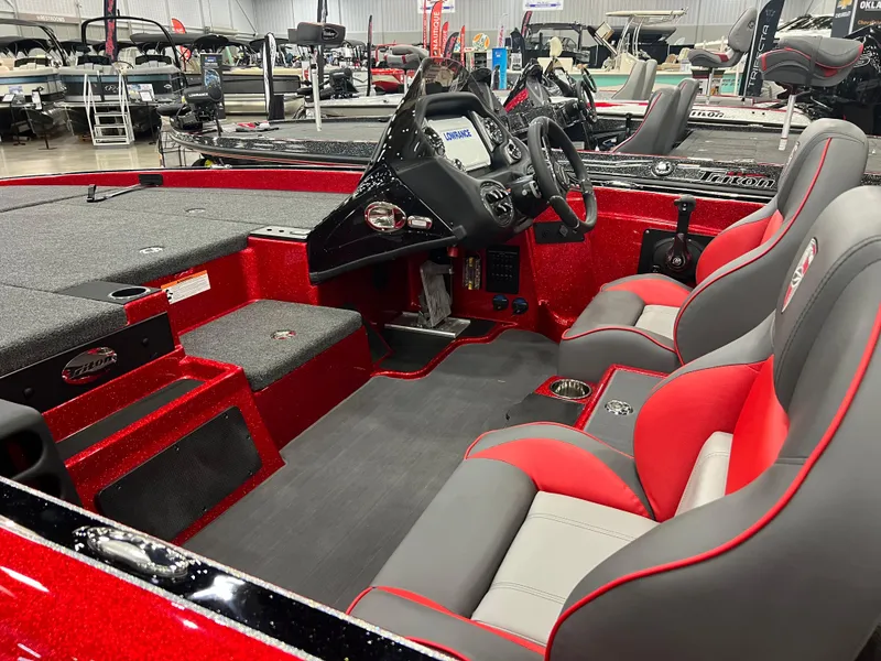 Slide: The Image of 2024 Triton 19 TrX Patriot boat interior with red and gray seats, steering console, and spacious deck. - 9