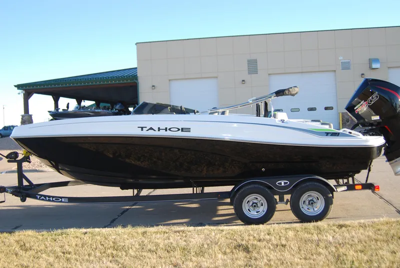Slide: The Image of 2024 Tahoe T21 boat on trailer outside a building. - 2
