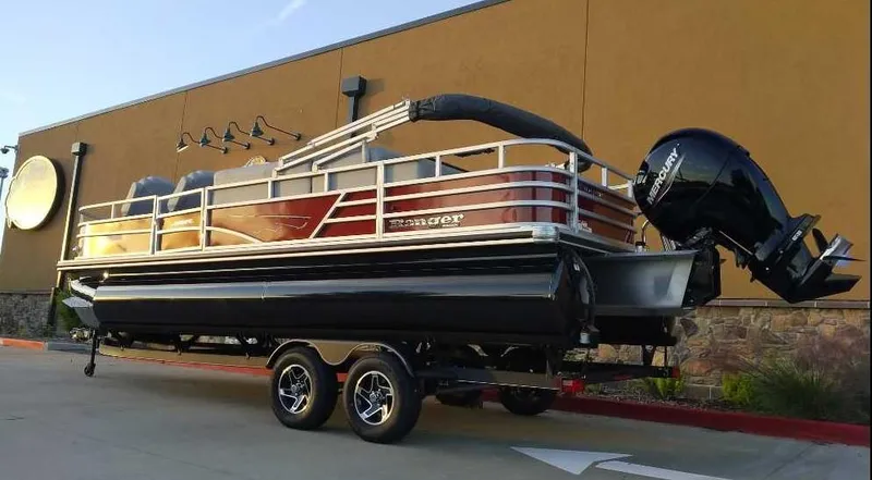 Slide: The Image of 2024 Ranger Reata 220FC pontoon boat on a trailer. - 2