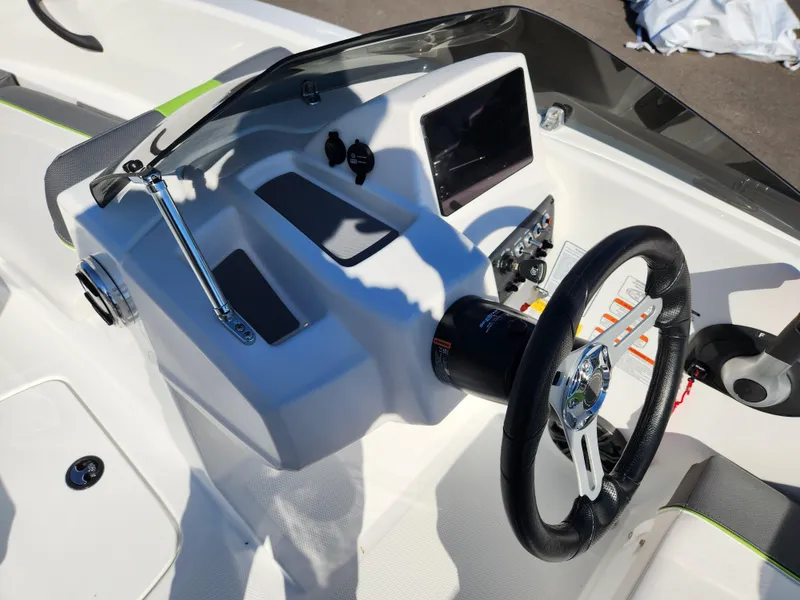 Slide: The Image of 2024 Tahoe T16 boat dashboard with steering wheel and control panel. - 14
