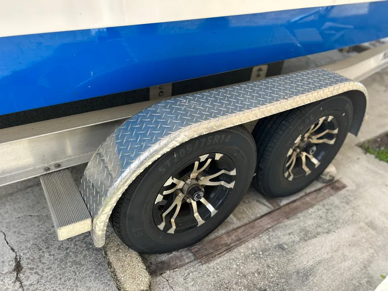 Slide: The Image of Trailer wheels of a 2020 Aquasport 244 Bay boat with diamond plate fender. - 11