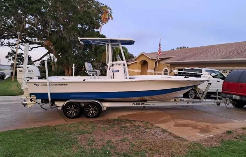 Slide: The Image of 2020 Aquasport 244 Bay boat on trailer in residential driveway. - 14
