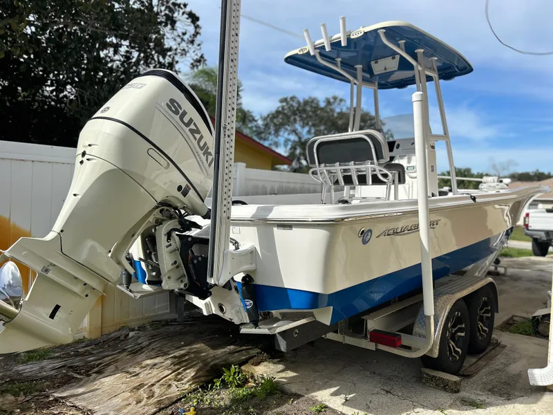 Slide: The Image of 2020 Aquasport 244 Bay boat with Suzuki outboard motor on trailer. - 2