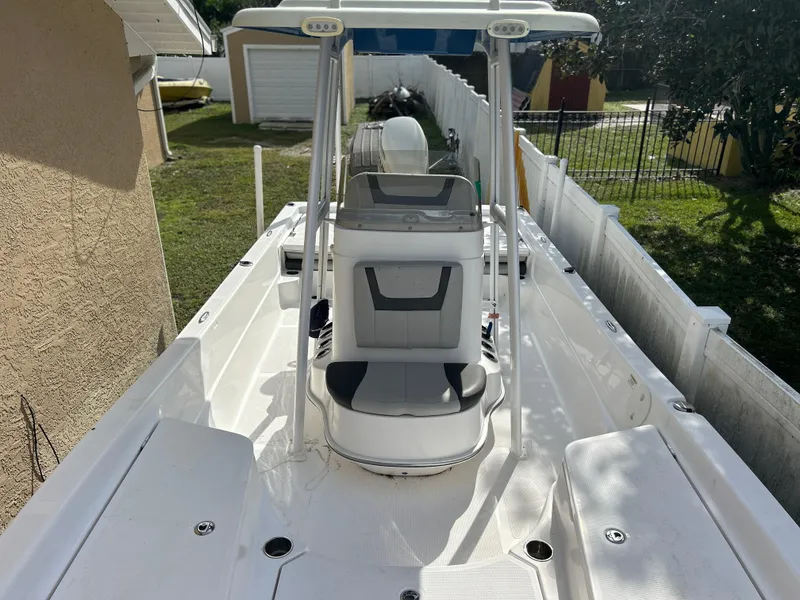 Slide: The Image of 2020 Aquasport 244 Bay boat with center console and seating, parked in a residential backyard. - 26
