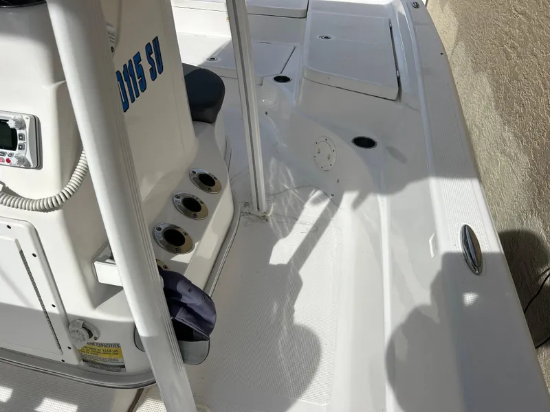 Slide: The Image of 2020 Aquasport 244 Bay boat interior with rod holders and seating area. - 30