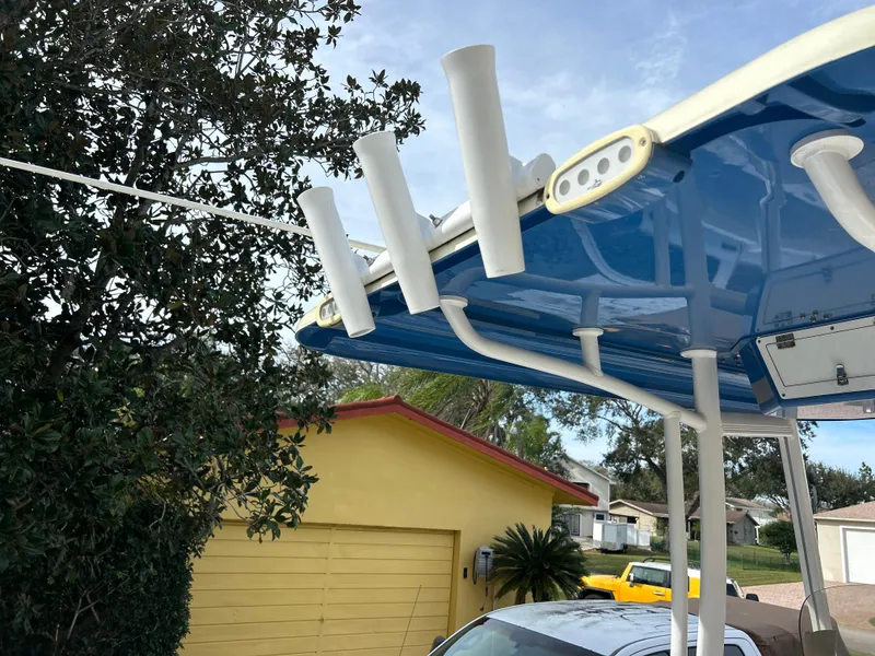 Slide: The Image of 2020 Aquasport 244 Bay boat with rod holders and blue canopy. - 31