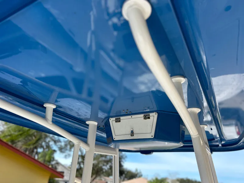 Slide: The Image of Close-up of 2020 Aquasport 244 Bay boat's blue T-top and storage compartment. - 32