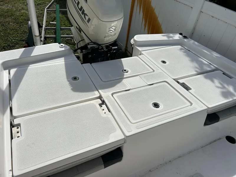 Slide: The Image of 2020 Aquasport 244 Bay boat with Suzuki outboard motor and storage compartments. - 43