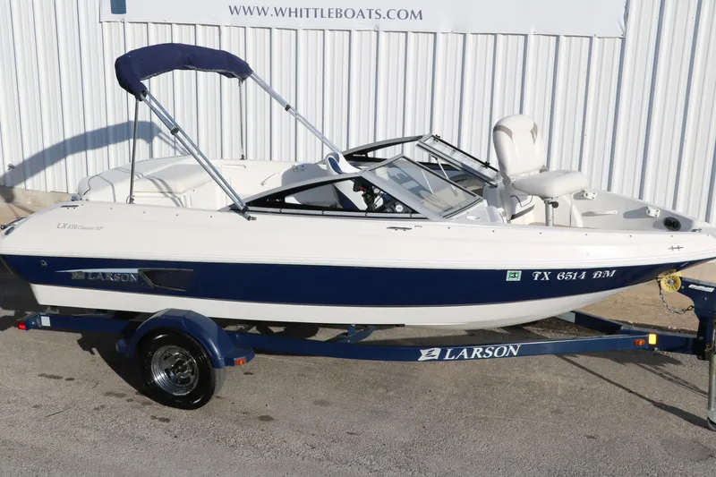 Slide: The Image of 2011 Larson LX850 Classic SF boat on trailer, white and blue, side view. - 12