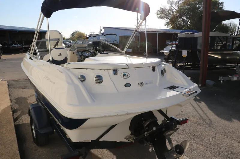 Slide: The Image of 2011 Larson LX850 Classic SF boat with outboard motor and trailer in a marina. - 5