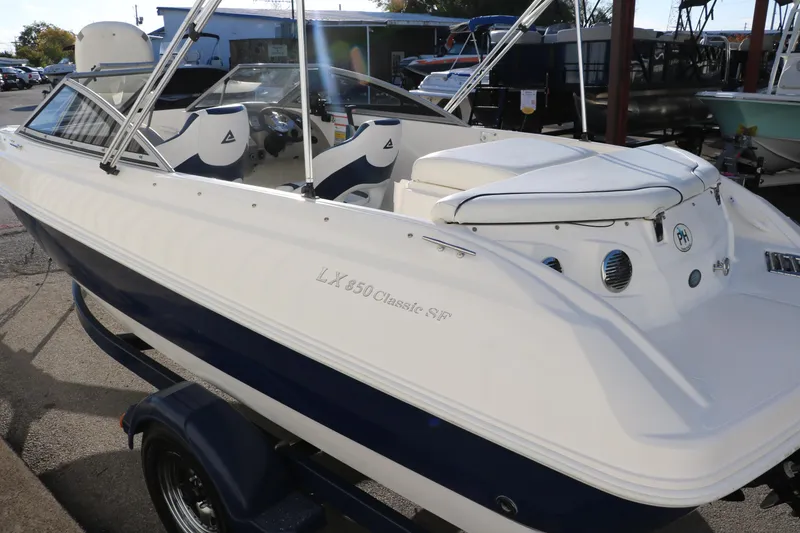 Slide: The Image of 2011 Larson LX850 Classic SF boat in white and blue, docked on a trailer. - 7