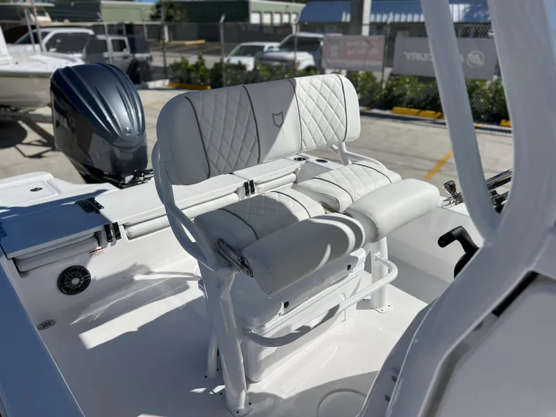 Slide: The Image of 2024 Sea Fox 251 Bay Fox boat interior with cushioned seating and outboard motor. - 18