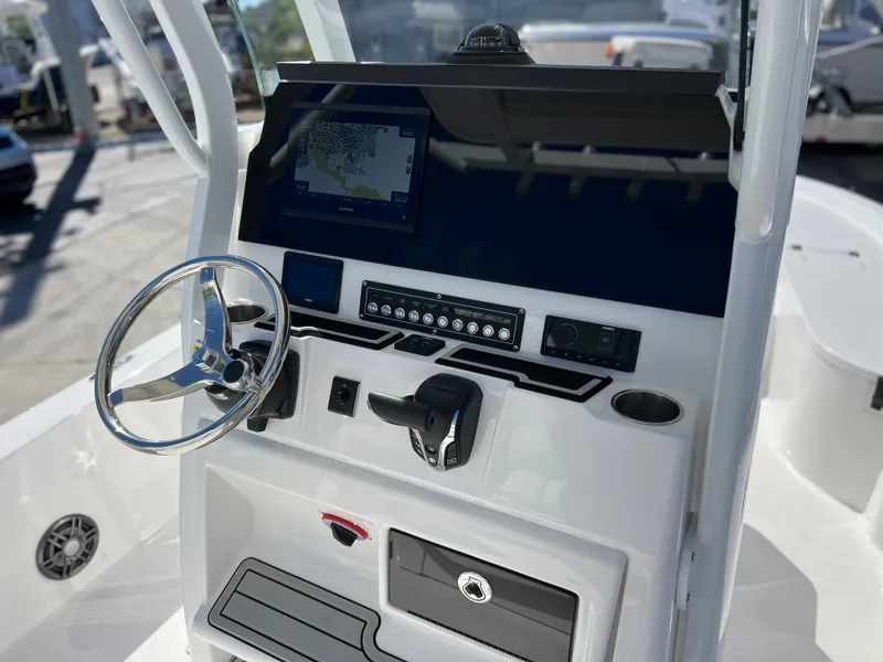 Slide: The Image of 2024 Sea Fox 251 Bay Fox boat with white cushioned seating and outboard motor. - 22