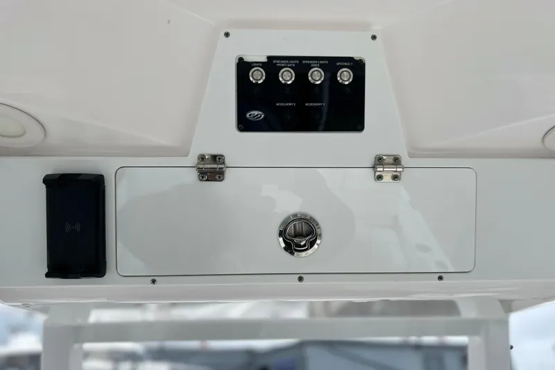 Slide: The Image of 2024 Sea Fox 251 Bay Fox control panel with switches and storage compartment. - 56