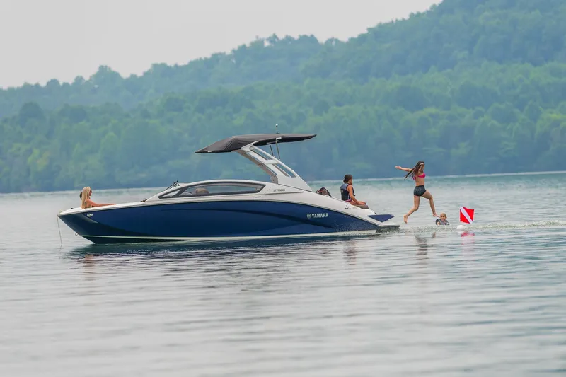 Slide: The Image of 2024 Yamaha Boats 275SE on a lake with people enjoying water activities. - 12