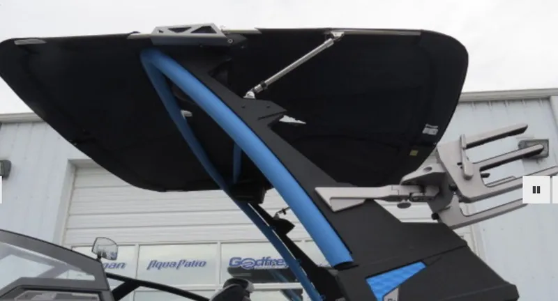 Slide: The Image of 2023 Malibu M220 boat with a black and blue wakeboard tower. - 3