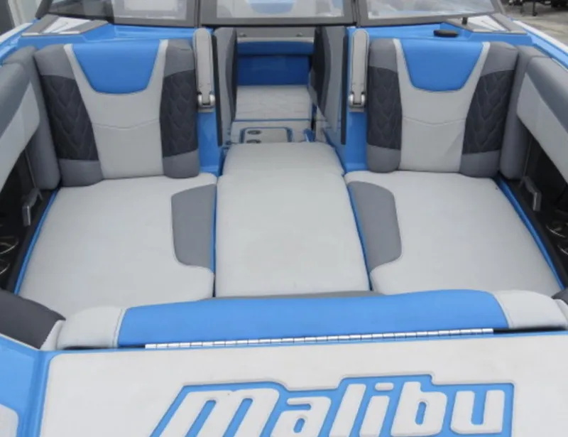 Slide: The Image of 2023 Malibu M220 boat interior with blue and gray seating. - 6