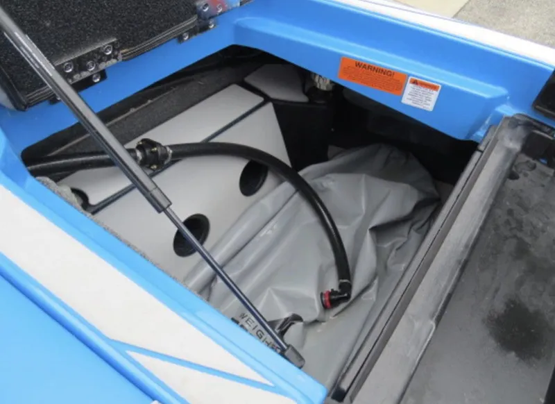 Slide: The Image of 2023 Malibu M220 boat storage compartment with ballast bag and hose. - 8