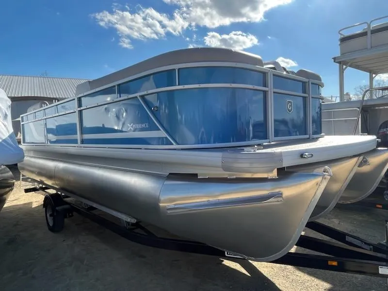 Slide: The Image of 2024 Sweetwater 2286SBCX pontoon boat with blue exterior on a trailer. - 1