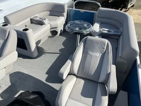 Slide: The Image of 2024 Sweetwater 2286SBCX pontoon boat interior with plush seating and table. - 13
