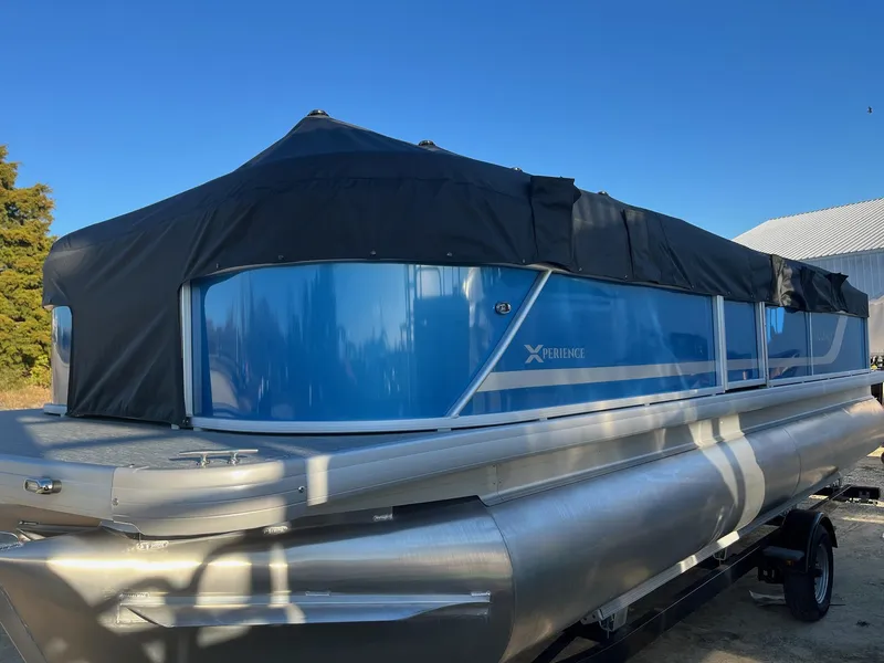 Slide: The Image of 2024 Sweetwater 2286SBCX pontoon boat with blue exterior and black cover. - 14