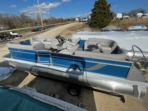 Slide: The Image of 2024 Sweetwater 2286SBCX pontoon boat in blue and silver on a trailer. - 5