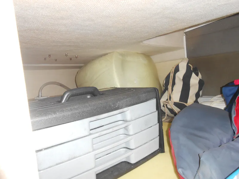 Slide: The Image of Storage compartment in a 2003 Glastron GS249 boat with various items. - 12