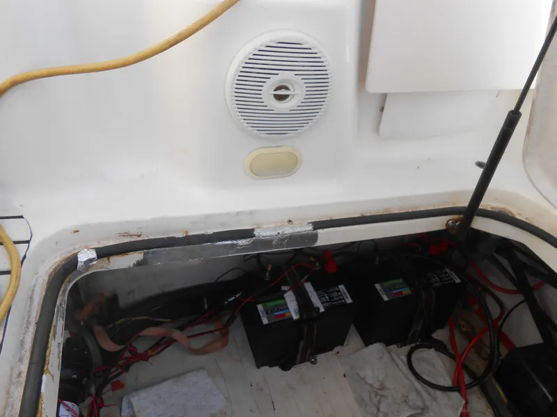 Slide: The Image of 2003 Glastron GS249 boat battery compartment with wiring and speaker. - 16