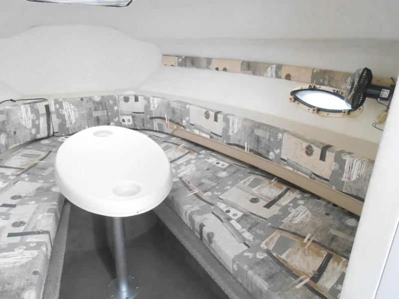 Slide: The Image of 2003 Glastron GS249 boat interior with patterned seating and round table. - 22